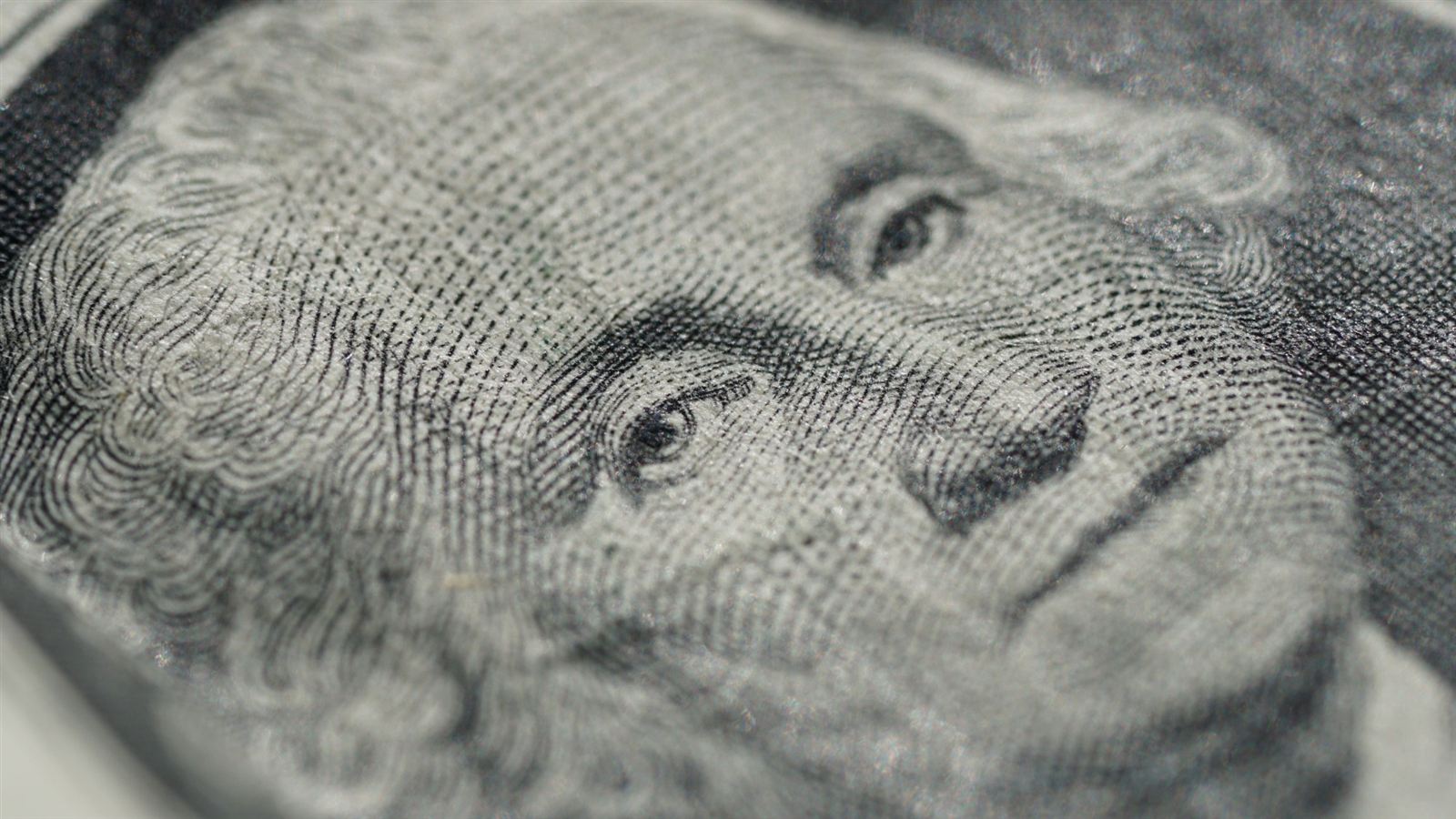 A close-up of the portrait on a dollar bill